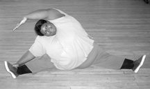 photo of large woman doing leg stretches on the floor